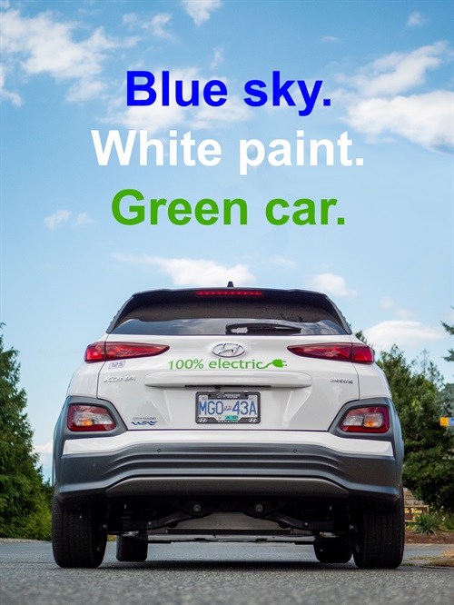 Kona electric car with text: blue sky. white paint. green car.