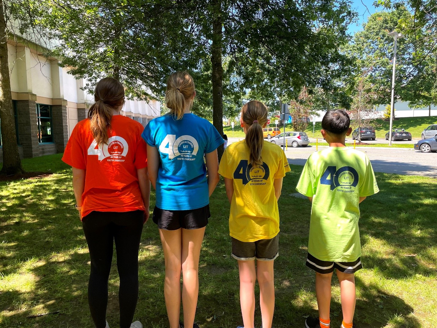 Four leaders in training from the back showing the 40 year t-shirts logo