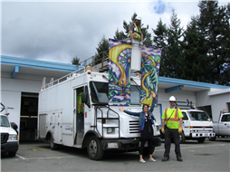 Photo of Laura, Roads crew, and her banner design