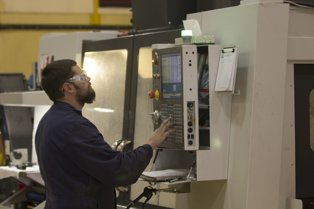 man entering commands into a computer panel