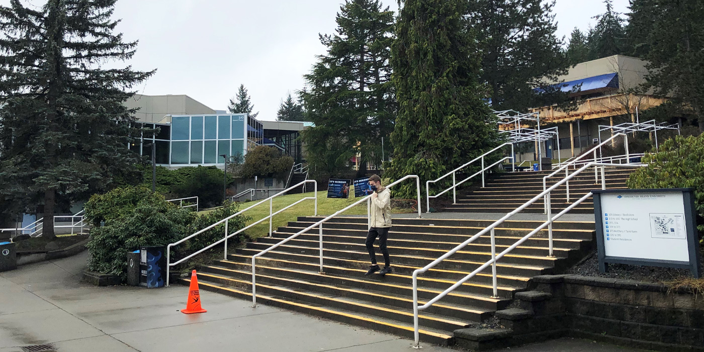 A student walks down the stairs at Vancouver Island University