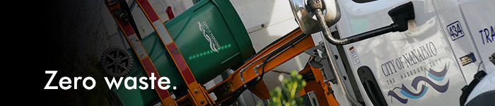 A recycling truck lifts a compost bin