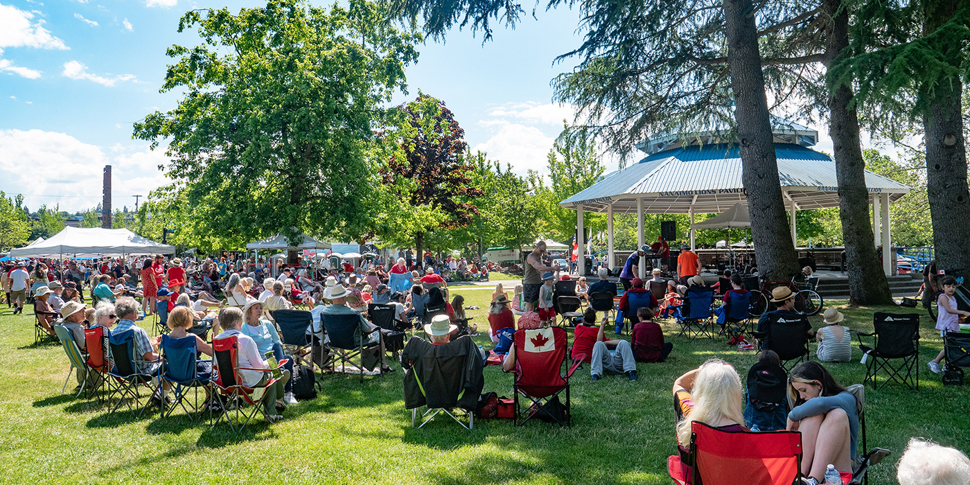 A crowd sits and watches a performance at Maffeo Sutton Park