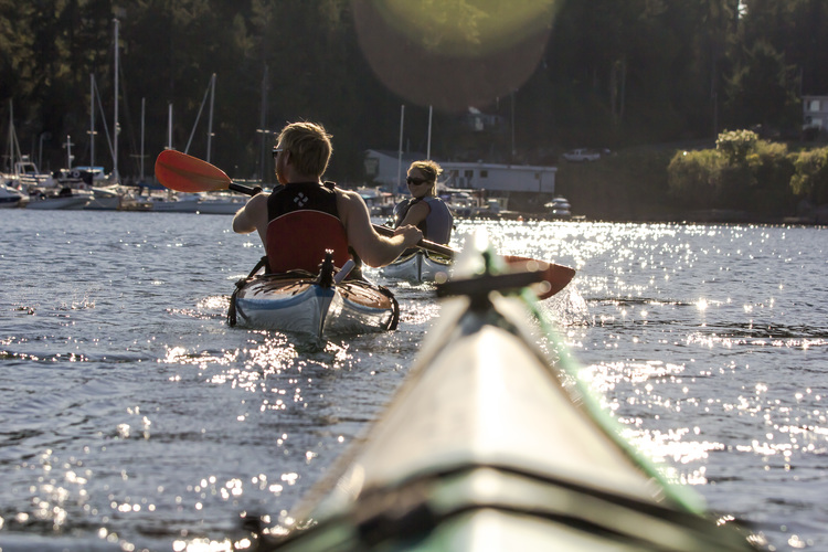 two people kayaking on reflective water