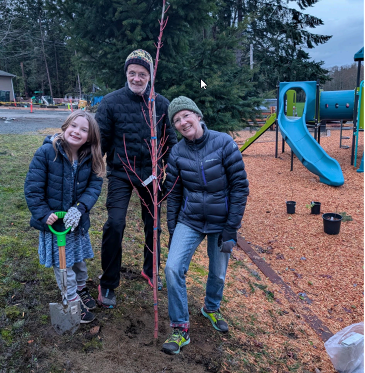 Three people in front of a playground