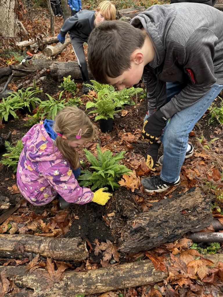a child and a man planting a plant