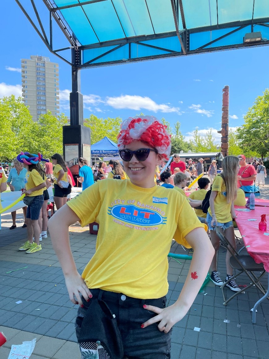 Leader in training wearing a red and white wig at the Canada Day event