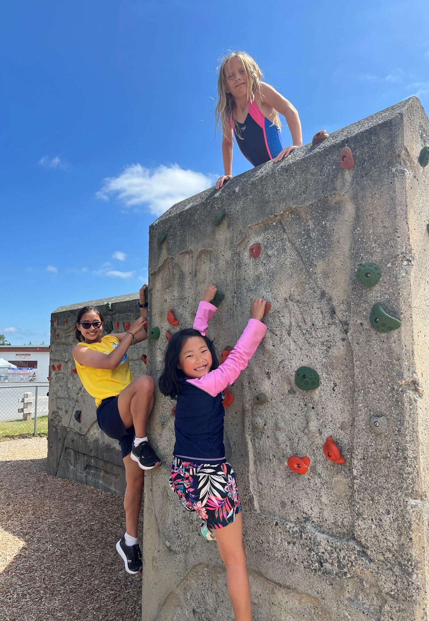 Youth leader and two children climbing a climbing wall