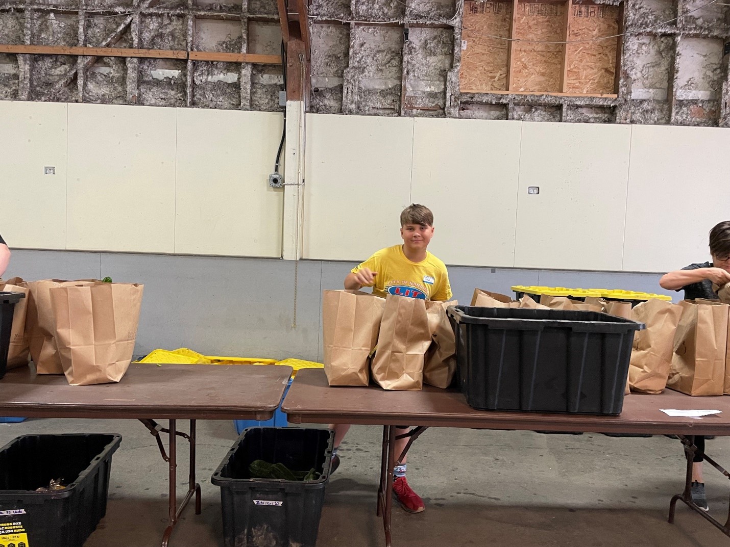 A leader in training helps bag food