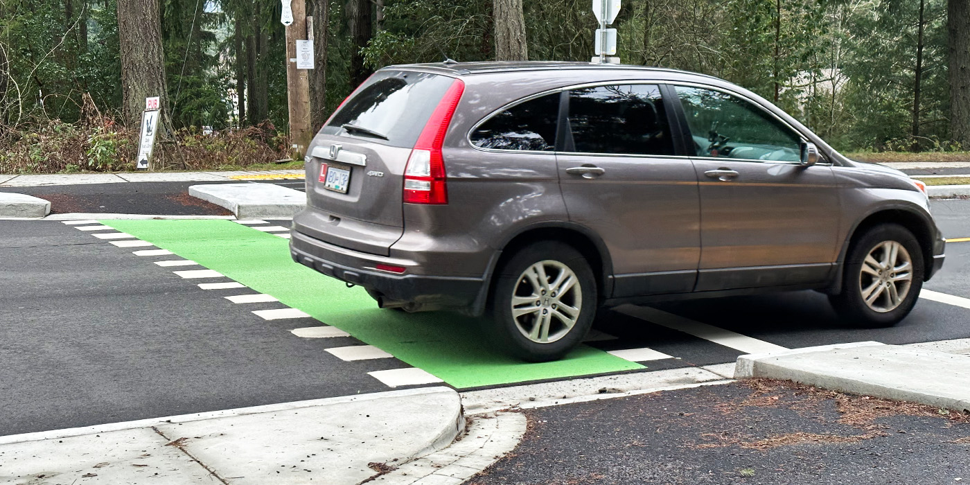 Car crosses over conflict zone and sidewalk on narrowed street