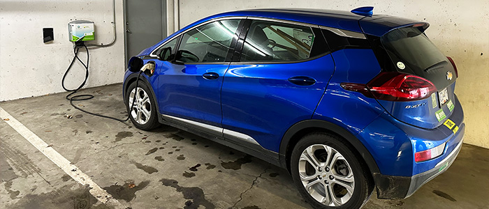 A blue Chevy Bolt charges at an EV charger in a parkade in Nanaimo.