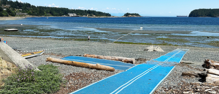 A blue Mobimat leading to the water at Departure Bay at low tide