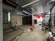 Largeopenspacewithmanstandingbyalargemetalbox