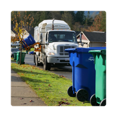 Garbage truck picking up cart and carts on the side of the road